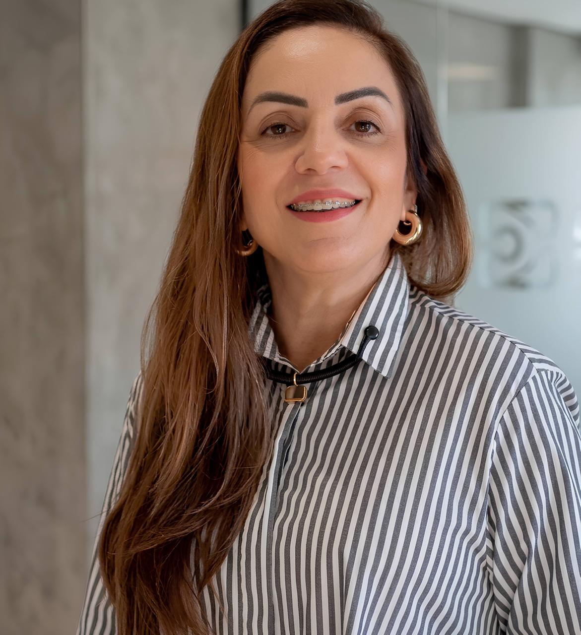Ani, fundadora da Ani Garcia Semijoias, sorrindo dentro da boutique